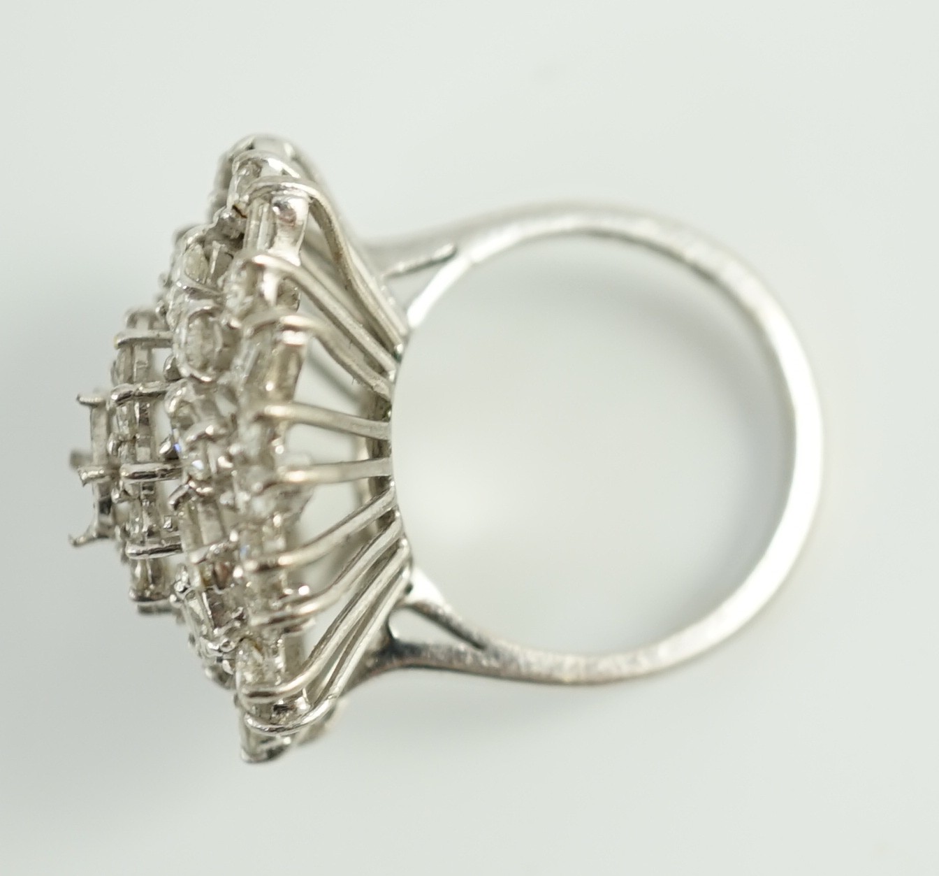 A modern 18ct white gold, ruby and round, baguette and marquise cut diamond cluster set dress ring